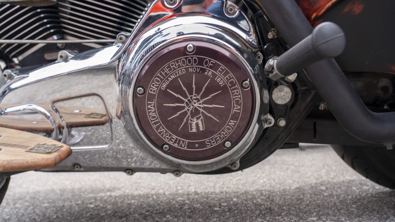 A chrome engine cover engraved with the International Brotherhood of Electrical Workers emblem and the 1891 founding year.
