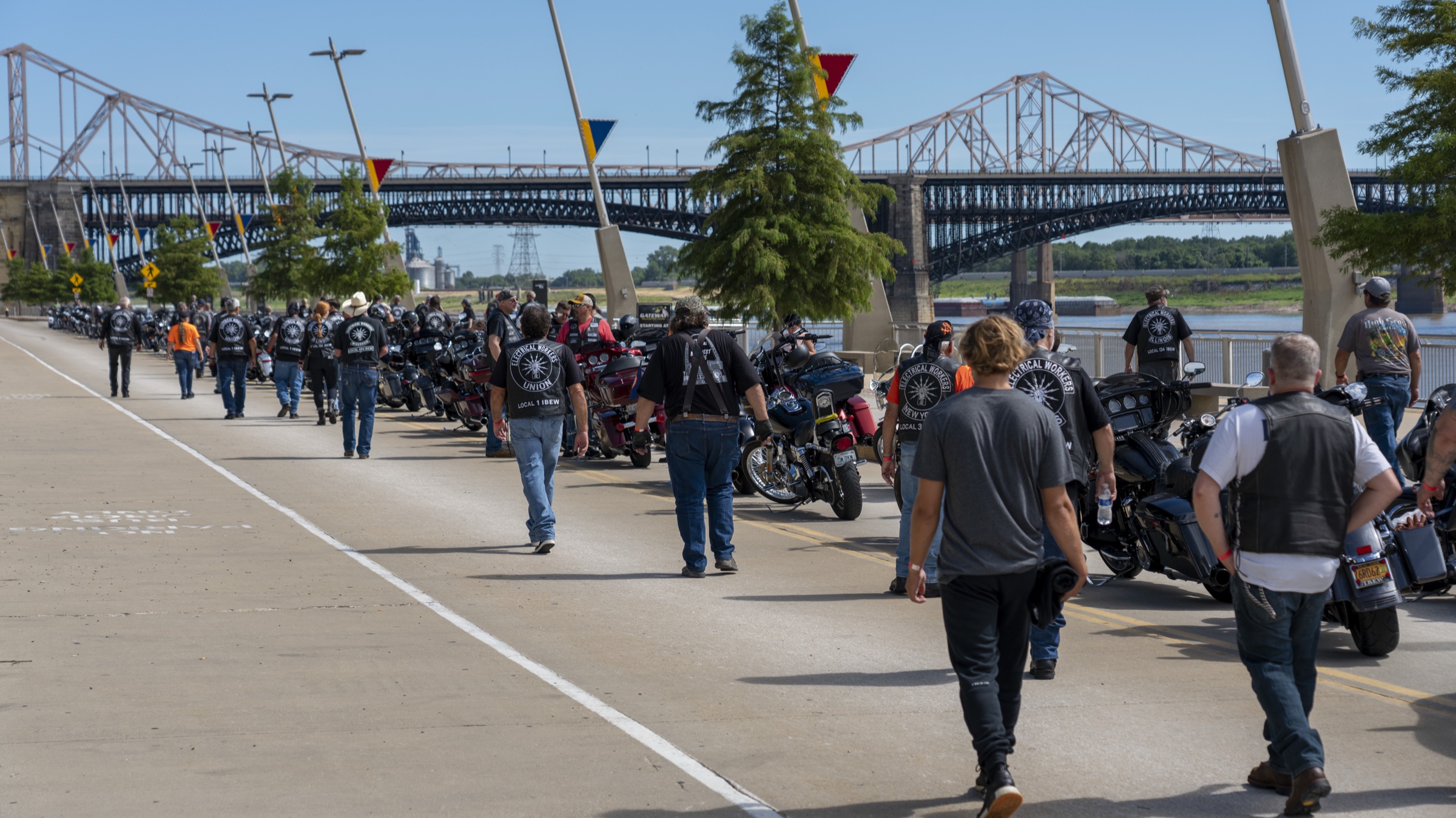 EWRC1 members lined up with their bikes on the St. Louis riverfront with the Eads and MacArthur bridges behind.